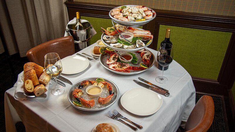 Raw bar & stone crab claws served with red and white wine on an upstairs table